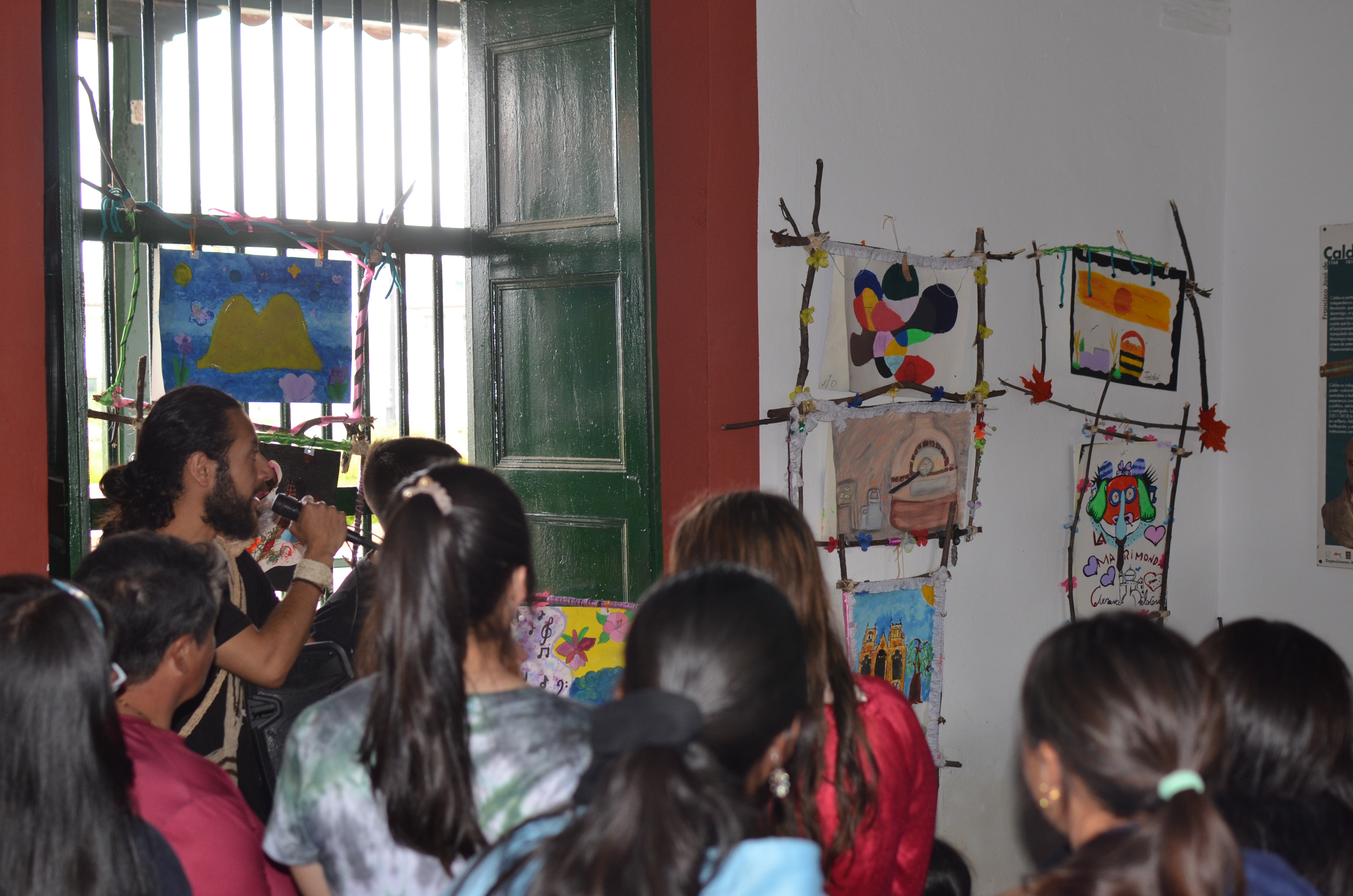 Un grupo de estudiantes y un profesor observando arte en una pared.